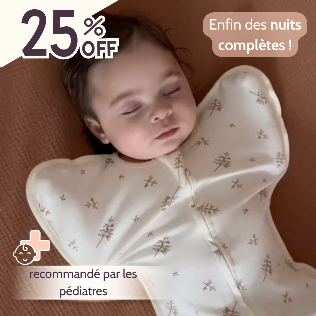 Un bébé dort dans son lit, emmailloté avec une emmailloteuse qui permet d'avoir les bras en position haute. Recommandé par les pédiatres.